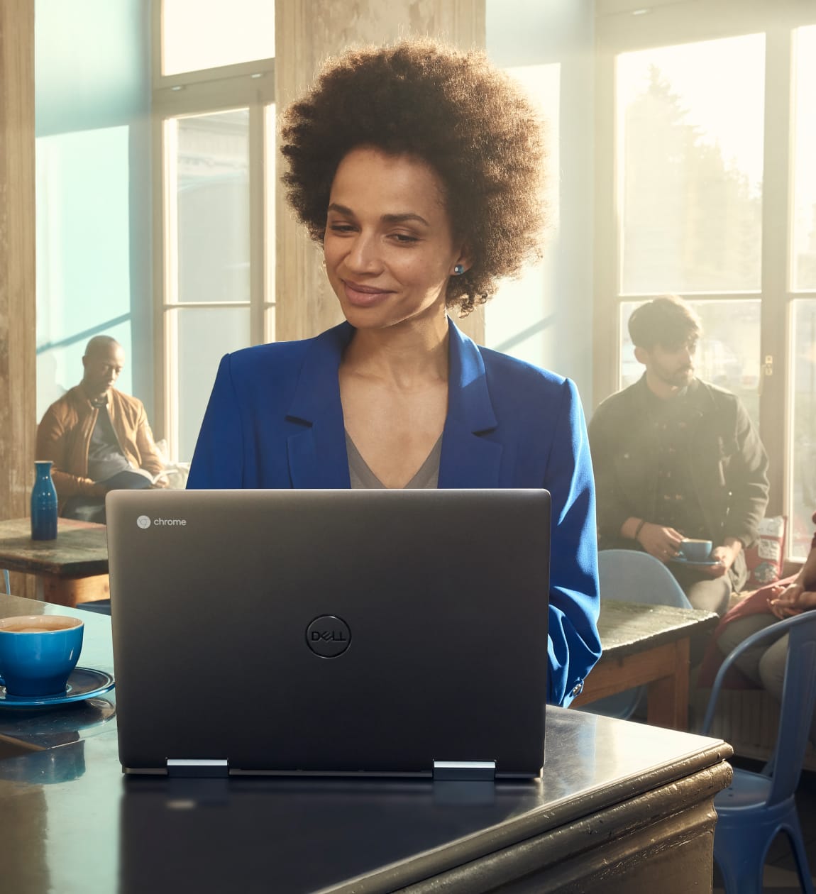 A mother in a coffee shop sets some device usage rules for her children from her Chromebook.